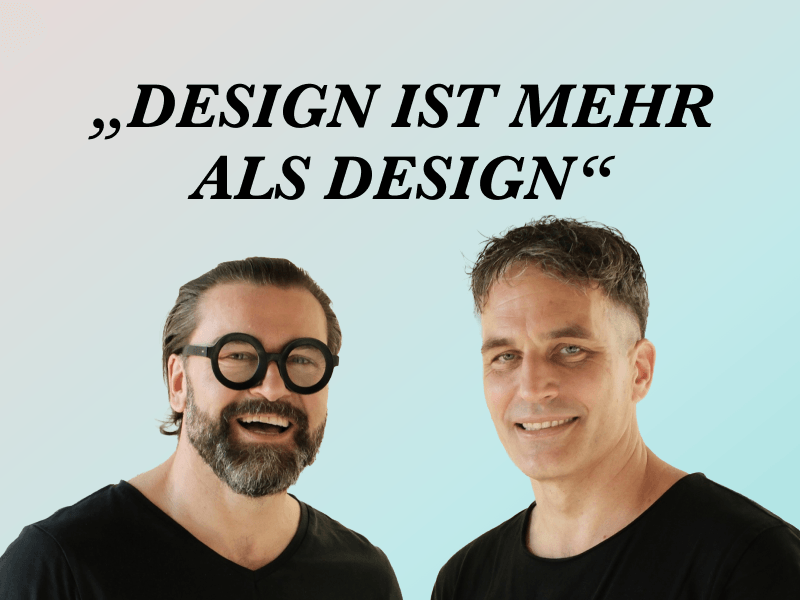 Zwei Männer lächeln vor einem Hintergrund mit dem Zitat Design ist mehr als Design.